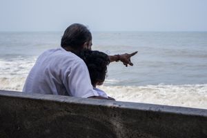 Grandfather and granddaughter looking at the sea