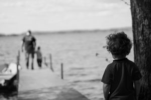 Grayscale photograph of child beside tree